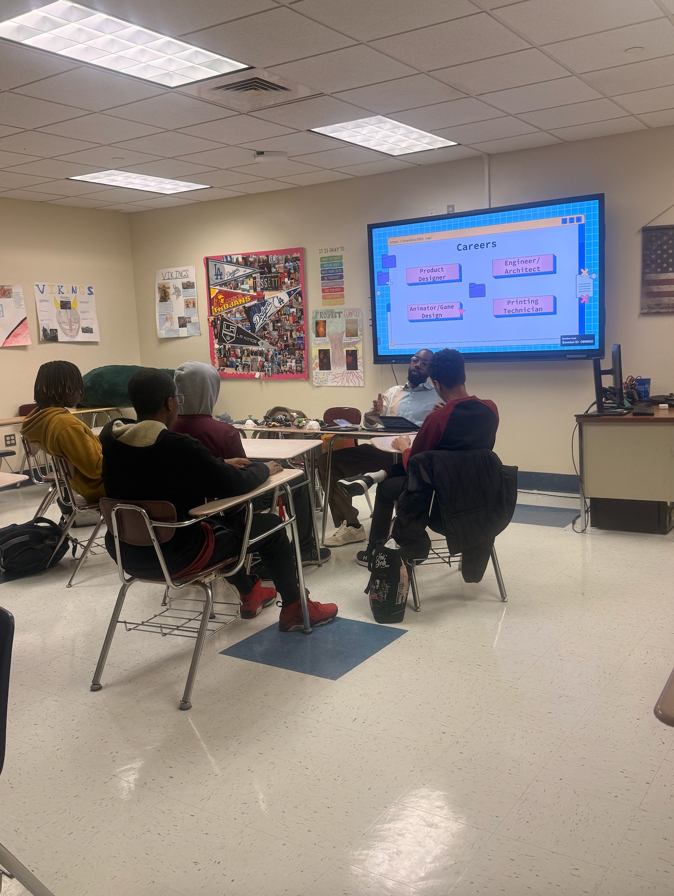 A mentor leading a discussion in front of a slide listing careers like product designer and game designer