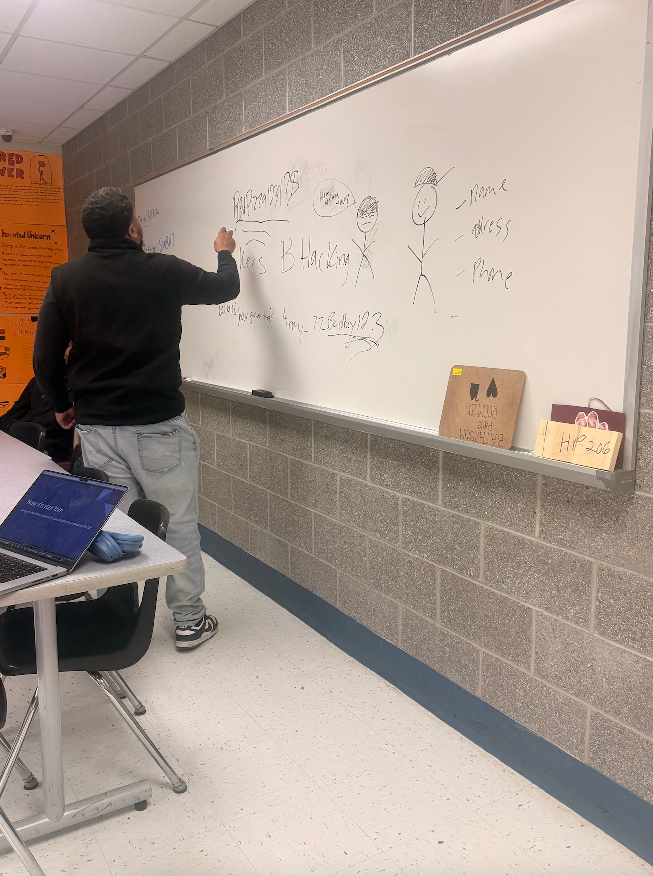 An instructor sketching password and hacking examples on a whiteboard