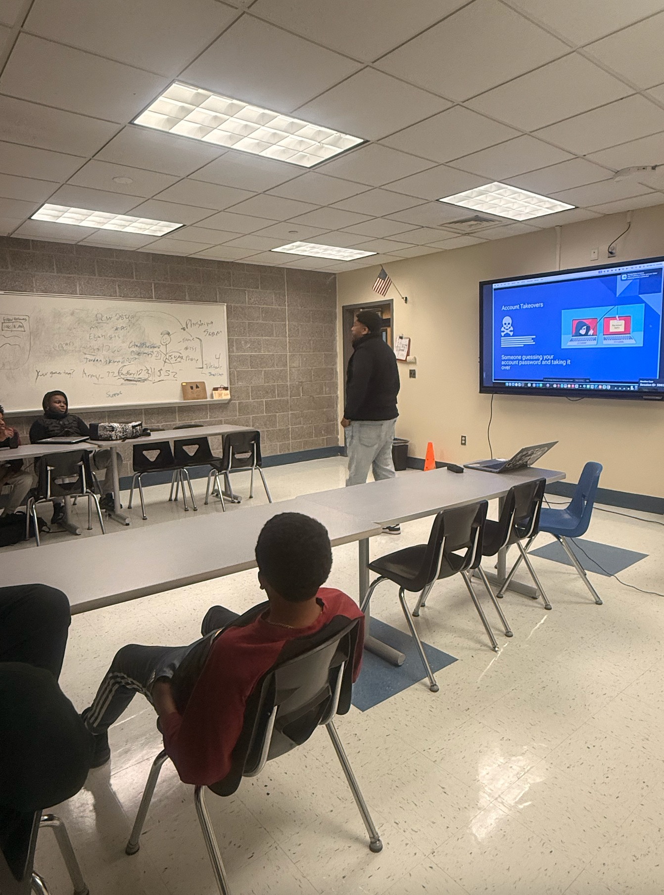 An instructor presenting a slide titled Account Takeovers to students